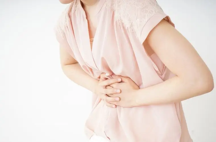 お腹が痛くてお腹を押さえる女性の写真｜腸活の前にやるべきこと｜消化力を整えて腸活効果を最大化する3ステップ