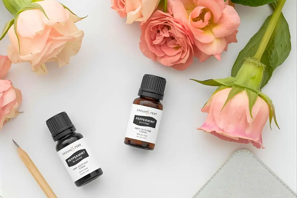 デスクに並べたローズマリー精油ボトルとローズの花｜午後の眠気をリセットする香り｜仕事中に集中を取り戻すアロマ5選